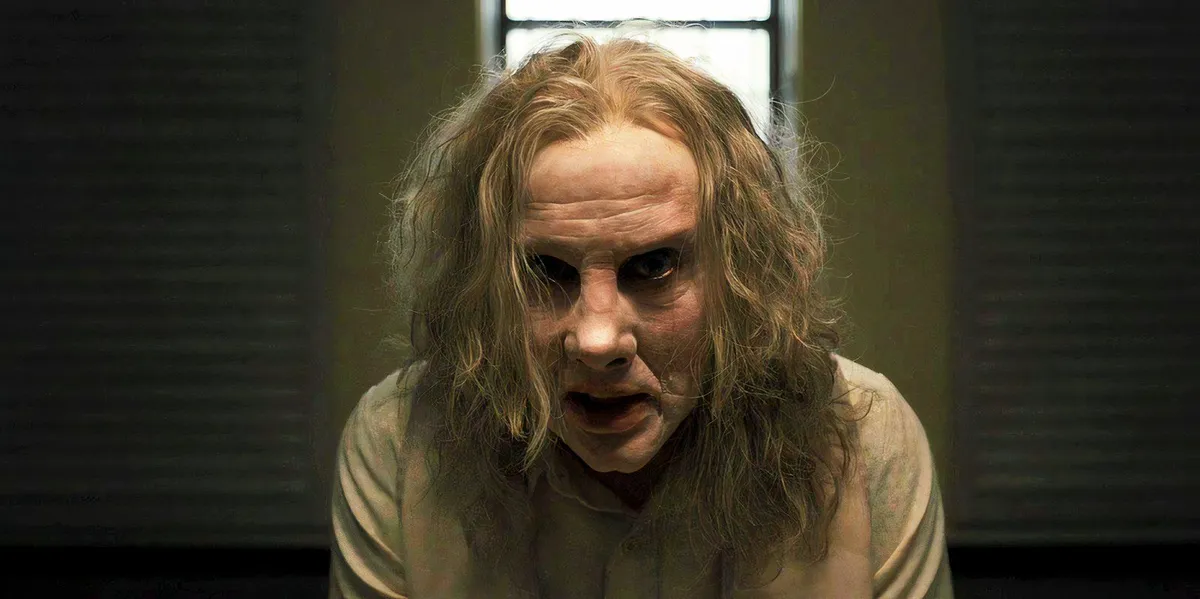 Nicolas Cage wearing prosthetics and staring intensely ahead as Longlegs