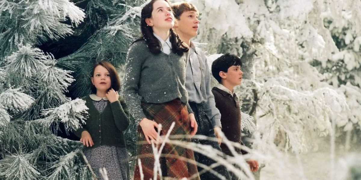 Georgie Henley Anna Popplewell William Moseley and Skandar Keynes as Lucy Susan Peter and Edmund walk out of the trees in The Chronicles of Narnia.