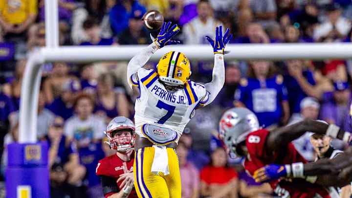 Sep 7, 2024; Baton Rouge, Louisiana, USA; Nicholls State Colonels quarterback Pat McQuaide (7) rolls out of the pocket against LSU Tigers linebacker Harold Perkins Jr. (7) during the second half at Tiger Stadium. Sep 7, 2024; Baton Rouge, Louisiana, USA; Nicholls State Colonels quarterback Pat McQuaide (7) rolls out of the pocket against LSU Tigers linebacker Harold Perkins Jr. (7) during the second half at Tiger Stadium.