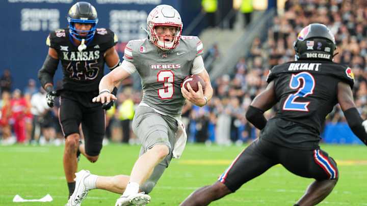 Sep 13, 2024; Kansas City, Kansas, USA; UNLV Rebels quarterback Matthew Sluka (3) runs the ball against Kansas Jayhawks defensive end Dean Miller (45) and cornerback Cobee Bryant (2) during the first half at Children's Mercy Park. Mandatory Credit: Jay Biggerstaff-Imagn Images Sep 13, 2024; Kansas City, Kansas, USA; UNLV Rebels quarterback Matthew Sluka (3) runs the ball against Kansas Jayhawks defensive end Dean Miller (45) and cornerback Cobee Bryant (2) during the first half at Children's Mercy Park. Mandatory Credit: Jay Biggerstaff-Imagn Images