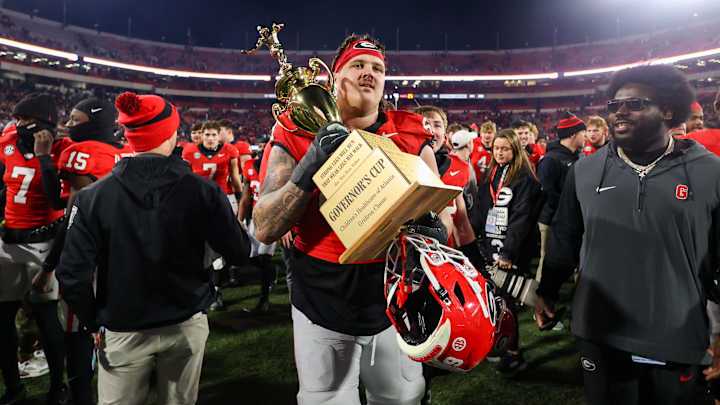 Nov 29, 2024; Athens, Georgia, USA; Georgia Bulldogs offensive lineman Tate Ratledge (69) holds the Governor’s Cup with running back Cash Jones (32) after a victory over the Georgia Tech Yellow Jackets in eight overtimes at Sanford Stadium. Mandatory Credit: Brett Davis-Imagn Images Nov 29, 2024; Athens, Georgia, USA; Georgia Bulldogs offensive lineman Tate Ratledge (69) holds the Governor’s Cup with running back Cash Jones (32) after a victory over the Georgia Tech Yellow Jackets in eight overtimes at Sanford Stadium. Mandatory Credit: Brett Davis-Imagn Images