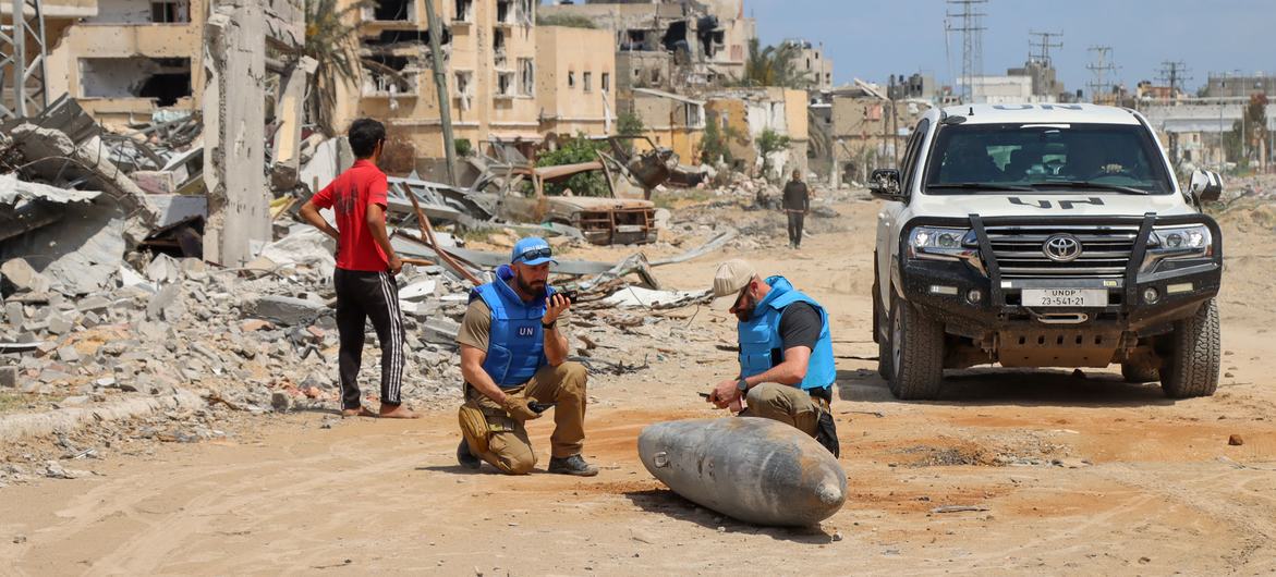 A UN team inspects an unexploded bomb lying on a main road in Khan Younis, Gaza. A UN team inspects an unexploded bomb lying on a main road in Khan Younis, Gaza.