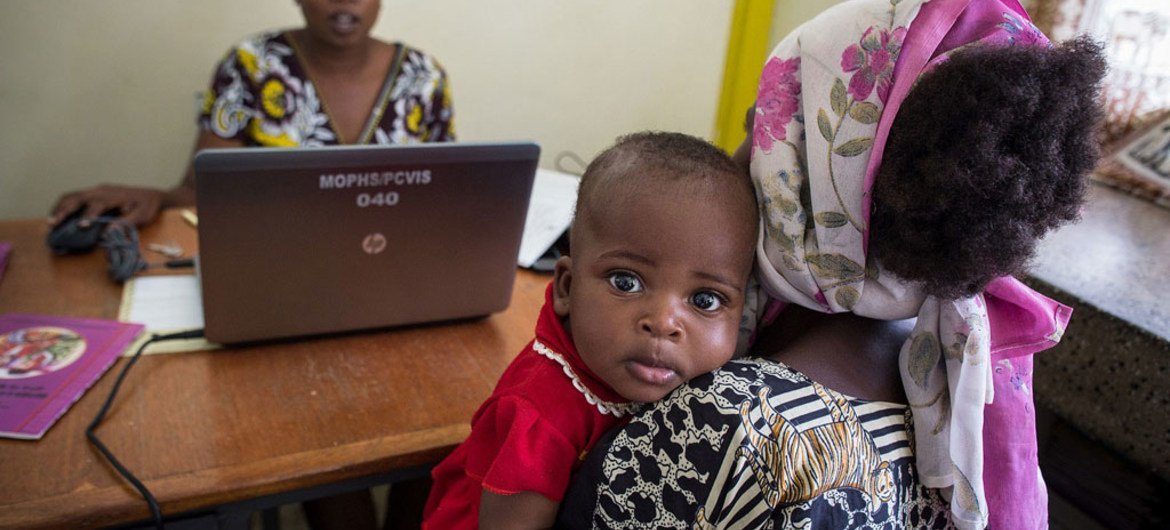 A baby has his general health recorded by a data clerk. A baby has his general health recorded by a data clerk.