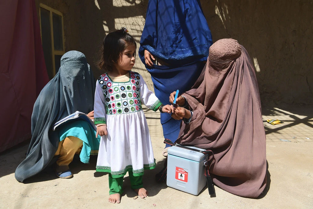 A child is vaccinated against polio during a polio mobillisation campaign in Kandahar, Afghanistan. A child is vaccinated against polio during a polio mobillisation campaign in Kandahar, Afghanistan.