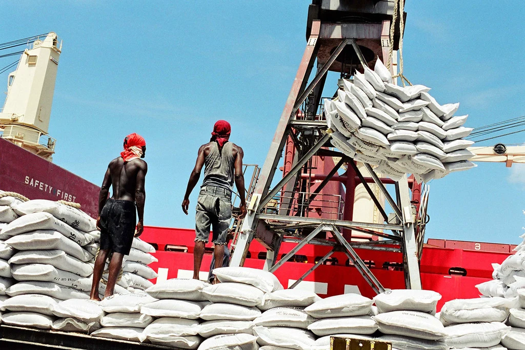 Dock workers unload cargo from a ship in Dar es Salaam, Tanzania. Dock workers unload cargo from a ship in Dar es Salaam, Tanzania.