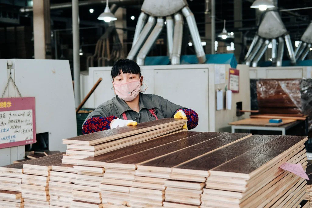 A worker at a factory in Zhejiang, China prepares wood for export. A worker at a factory in Zhejiang, China prepares wood for export.