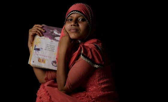 A fourteen year-old Rohingya refugee holds her favorite book of poetry at a refugee camp in Cox's Bazaar, Bangladesh. A fourteen year-old Rohingya refugee holds her favorite book of poetry at a refugee camp in Cox's Bazaar, Bangladesh.