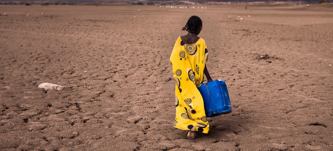 A girl walks with a water container in the Afar region in Ethiopia. A girl walks with a water container in the Afar region in Ethiopia.