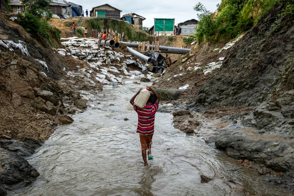 A boy carries water in a refugee camp in Cox's Bazar, Bangladesh. A boy carries water in a refugee camp in Cox's Bazar, Bangladesh.
