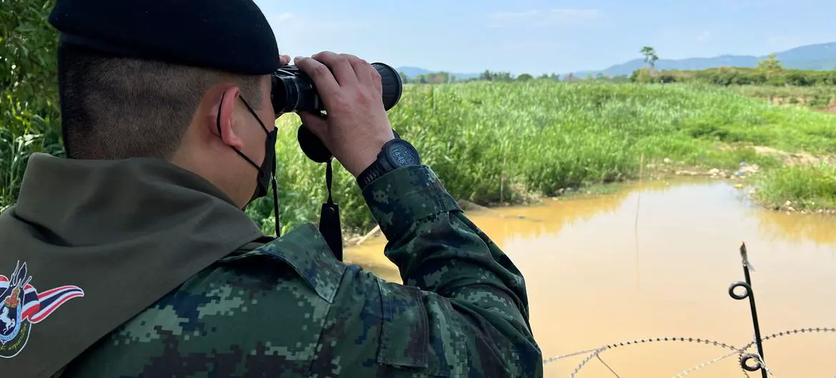 A Thai border officer looks into Myanmar across the frontier between the two countries. A Thai border officer looks into Myanmar across the frontier between the two countries.
