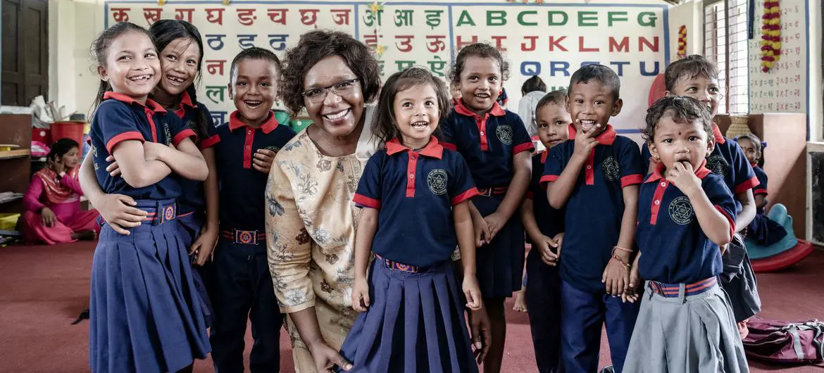 Alice Akunga, UNICEF Representative to Nepal, with a group of young children in a classroom.