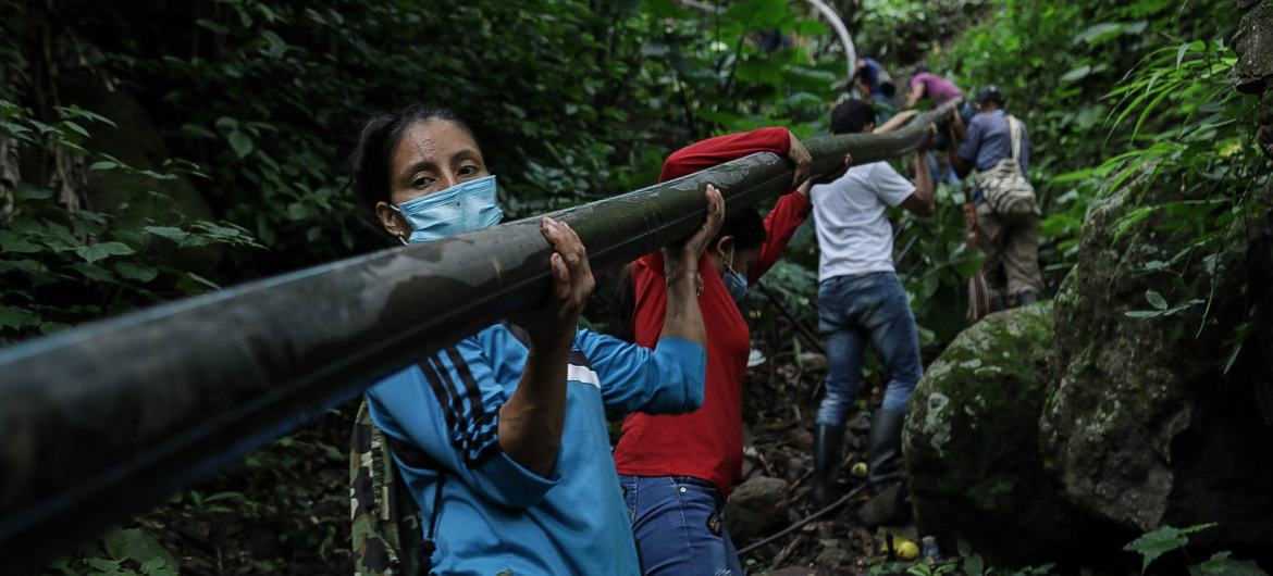 Yarledys Olaya (left) works alongside other former combatants and local people to laya water pipe. Yarledys Olaya (left) works alongside other former combatants and local people to laya water pipe.