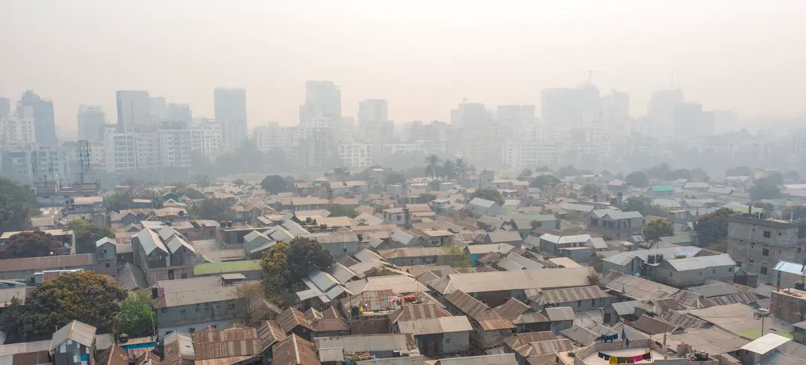 In Dhaka, stark inequality is laid bare as informal settlements sprawl in the foreground, shadowed by rising high-rises in the distance. In Dhaka, stark inequality is laid bare as informal settlements sprawl in the foreground, shadowed by rising high-rises in the distance.