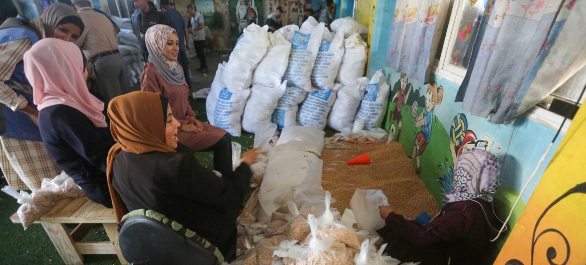 UNRWA staff distribute food to displaced families in Deir Al-Balah, Gaza. UNRWA staff distribute food to displaced families in Deir Al-Balah, Gaza.
