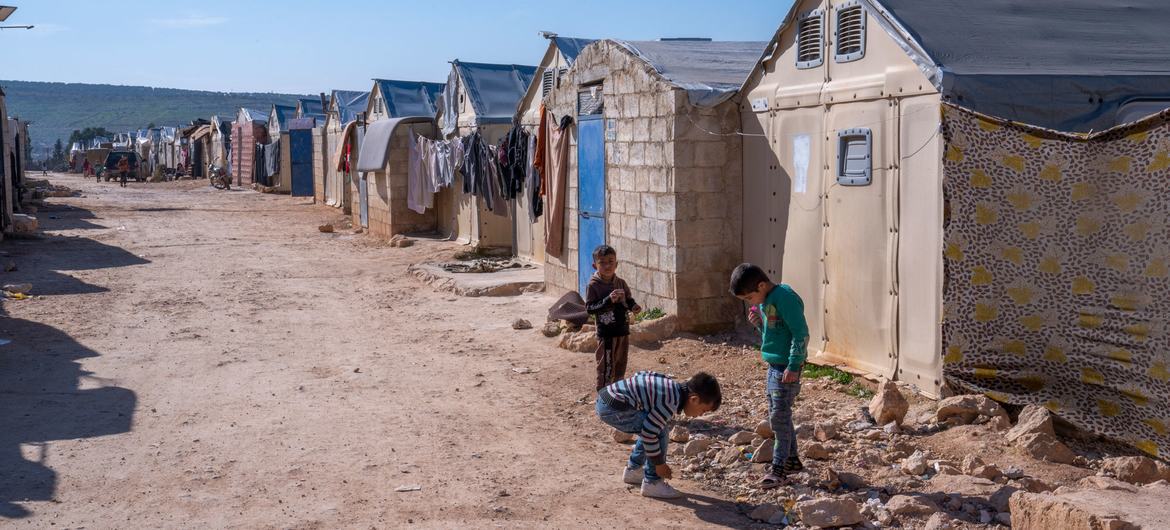 Boys play in an informal camp in Syria. Boys play in an informal camp in Syria.