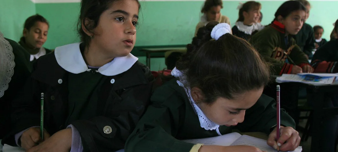 Girls work at a shared desk during a lesson at Omar Ben al-Khattab School in the town of Beit Lahia, in the northern Gaza Strip. (file)