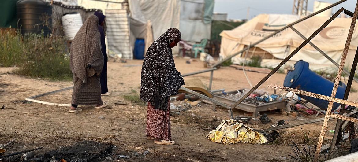 Women stand in a damaged displacement settlement in Khan Younis, Gaza. Women stand in a damaged displacement settlement in Khan Younis, Gaza.