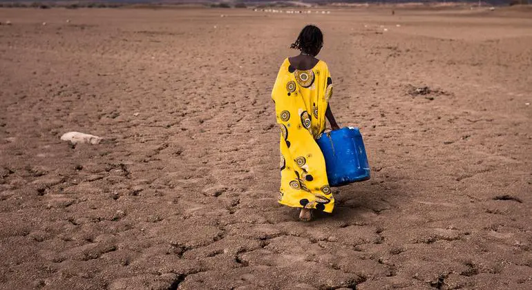 A girl walks with a water container in the Afar region in Ethiopia. A girl walks with a water container in the Afar region in Ethiopia.
