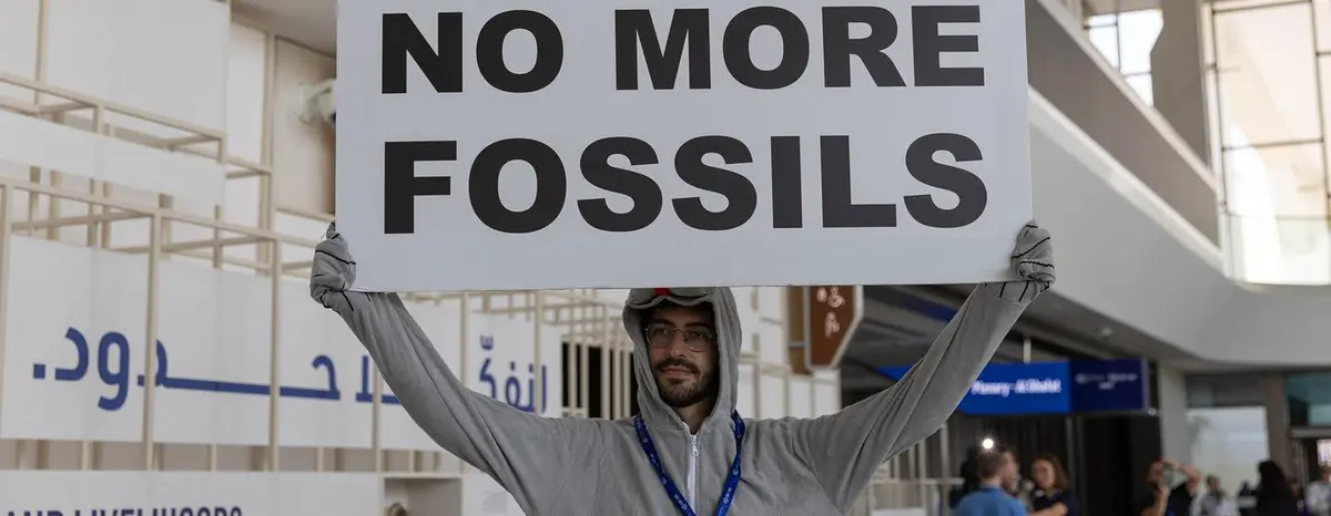 A man protests against fossil fuels at an international climate meeting in Dubai in 2023.