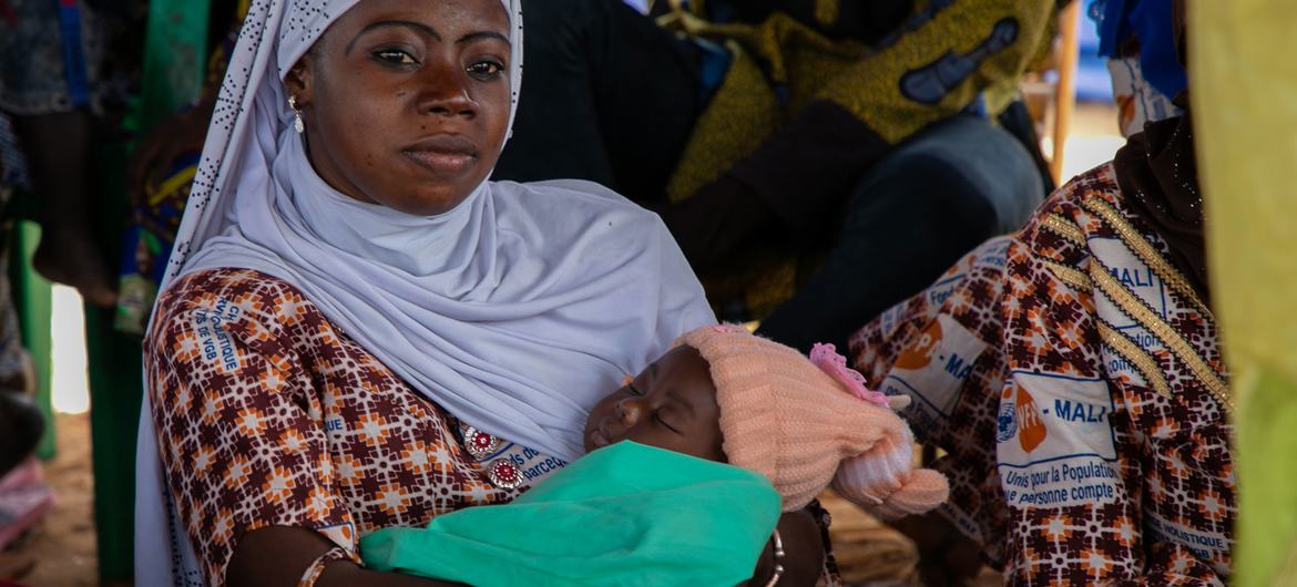 A woman with her baby listens to UNFPA staff at an awareness raising session on gender-based violence at the One Stop Centre in Sominé Dolo Hospital. A woman with her baby listens to UNFPA staff at an awareness raising session on gender-based violence at the One Stop Centre in Sominé Dolo Hospital.
