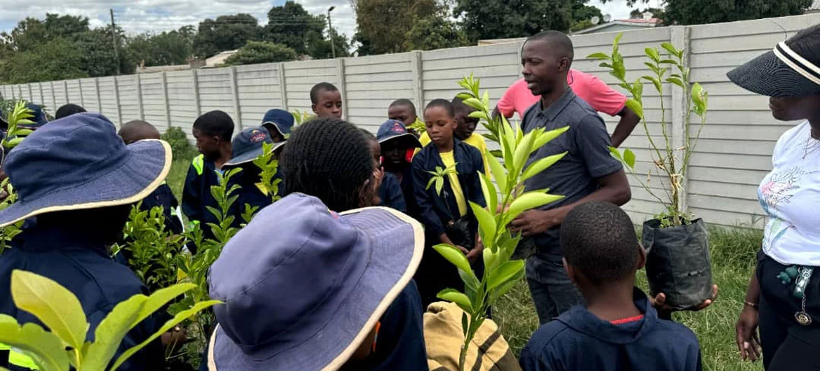Takudzwa Ashley Mlambo (right) talks to young people in a garden in Zimbabwe. Takudzwa Ashley Mlambo (right) talks to young people in a garden in Zimbabwe.