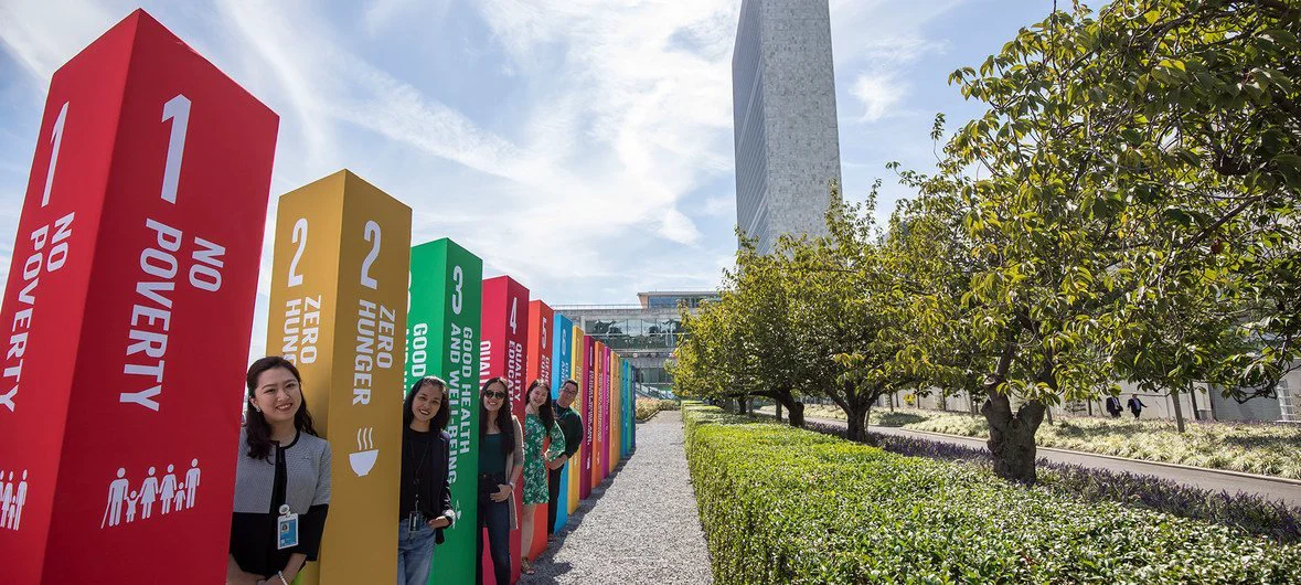 Young people line up along side a display at UN headquarters in New York representing the 17 Sustainable Development Goals .