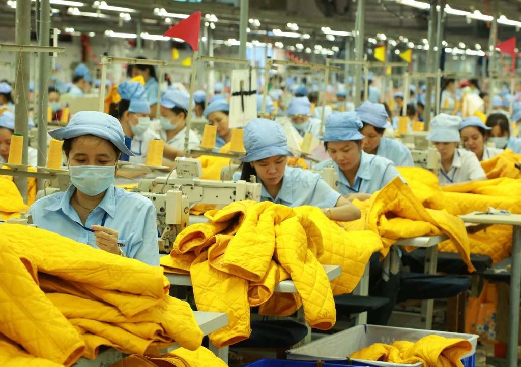 Women workers at a textile factory in Viet Nam stitch puffer jackets, destined mostly for Western markets. Women workers at a textile factory in Viet Nam stitch puffer jackets, destined mostly for Western markets.