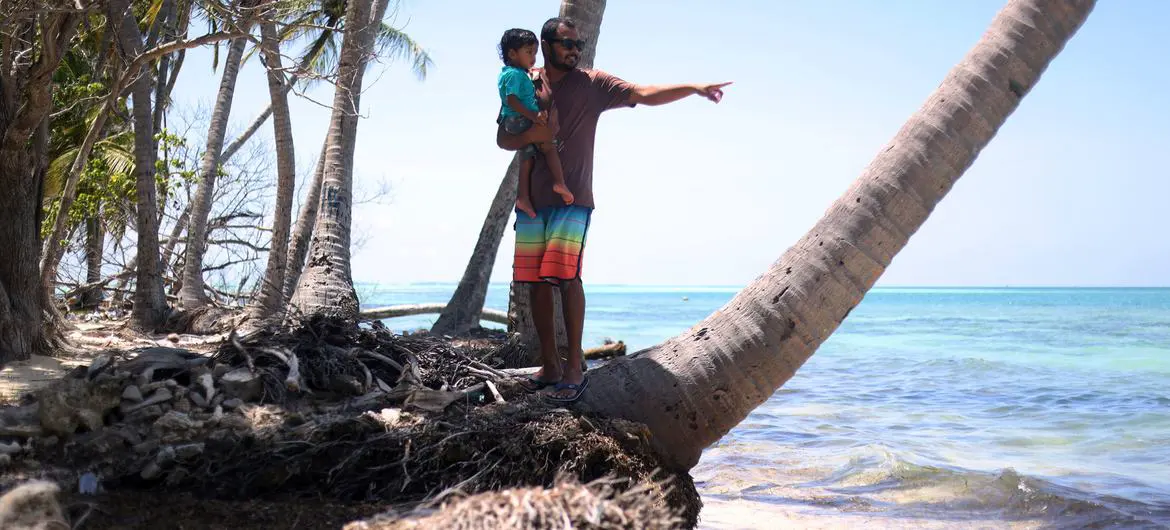 A father and his daughter on a stretch of severely eroded beach in Dhiffushi island, in the Maldives. 