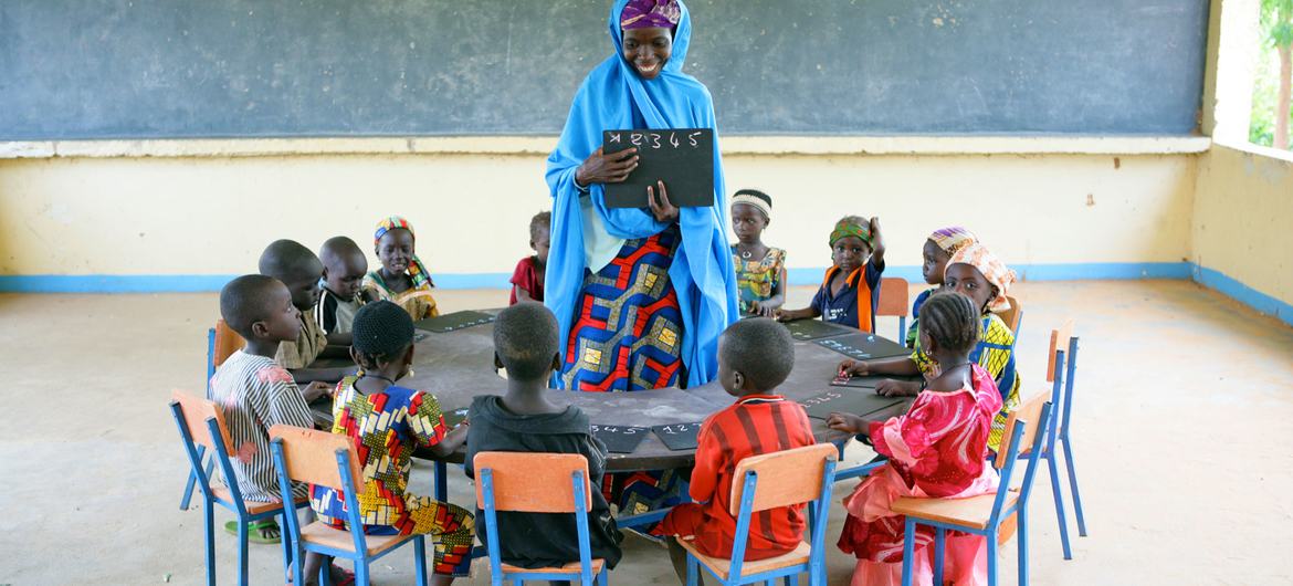 Children sit in a circle with their teacher at the Early Child Development centre in Garin Badjini village, south east Nigeria. Children sit in a circle with their teacher at the Early Child Development centre in Garin Badjini village, south east Nigeria.