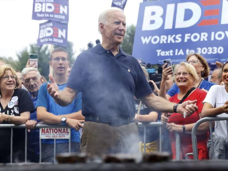 unnamed file Joe Biden works the grill during the Polk County Democrats Steak Fry in Des Moines, Iowa. Credit: Charlie Neibergall/AP