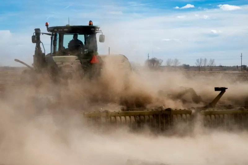 Paul Schlagel drives a vertical tillage tractor on his farm where he grows barley and beets on Dec. 23, 2021, in Longmont. Credit: Olivia Sun/The Colorado Sun