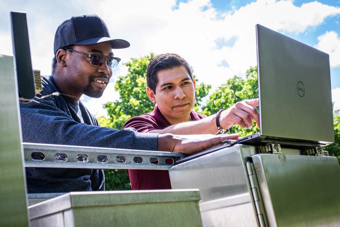 (From left) Samuel Daramola and David Munoz analyze water level data to better predict future storms.