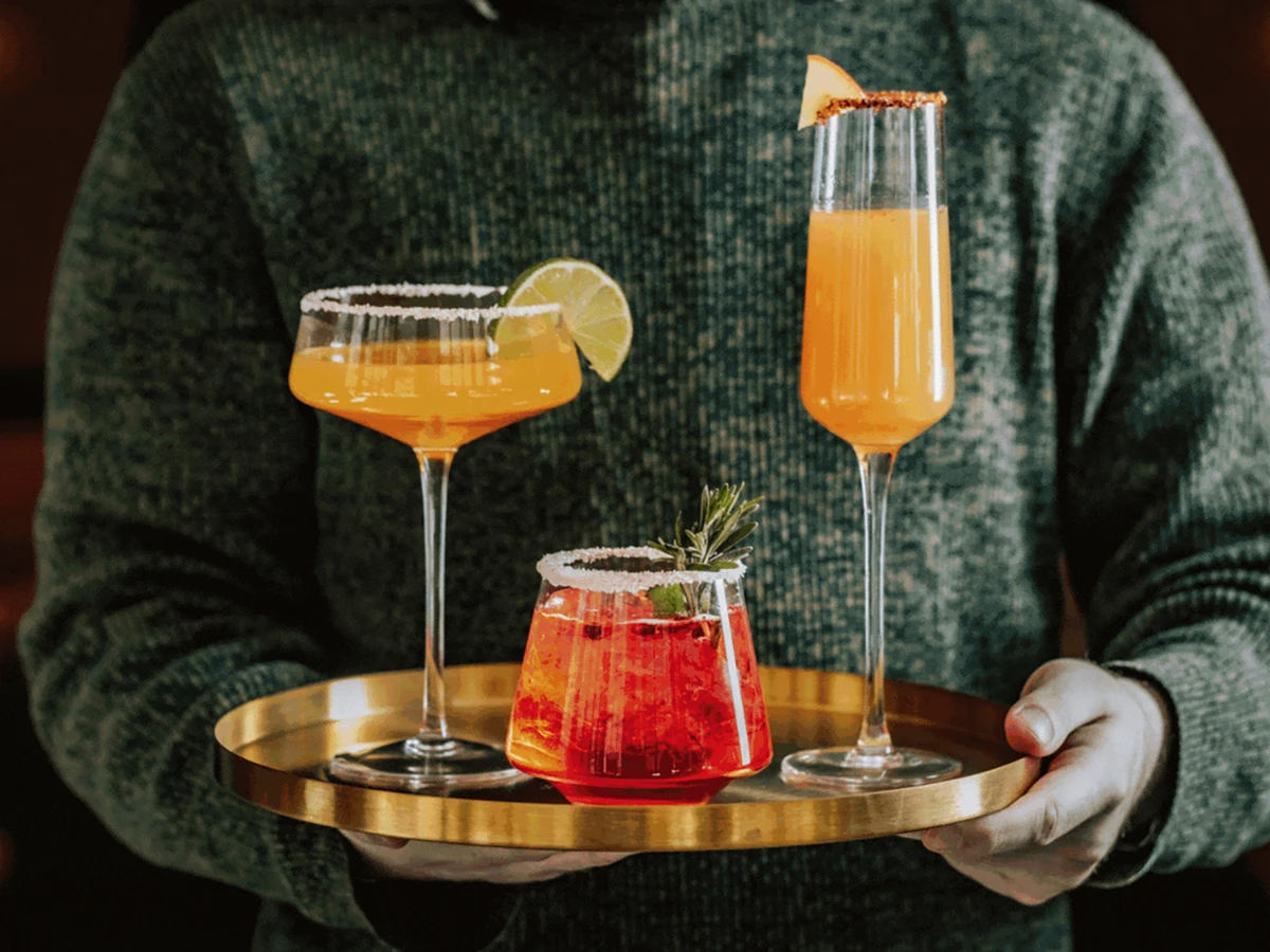 Three cocktails on a gold tray