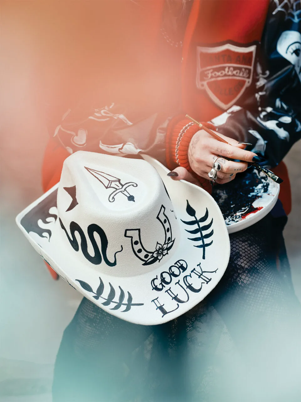 A white cowboy hat with black tattoo designs