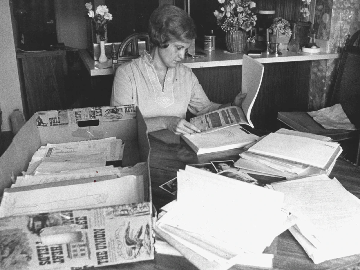 An old newspaper photo of a woman looking through Thomas Riha’s court documents