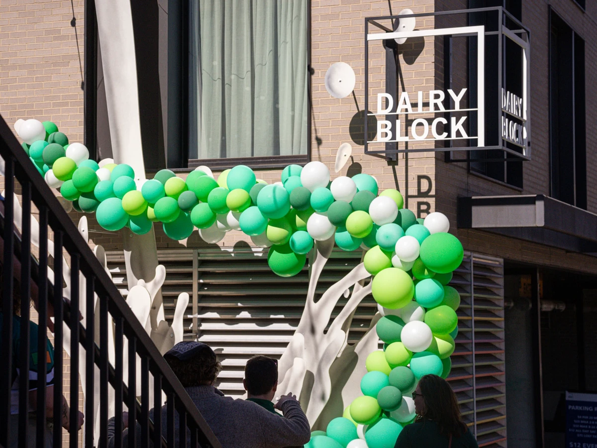 Green balloon arch below the Dairy Block sign