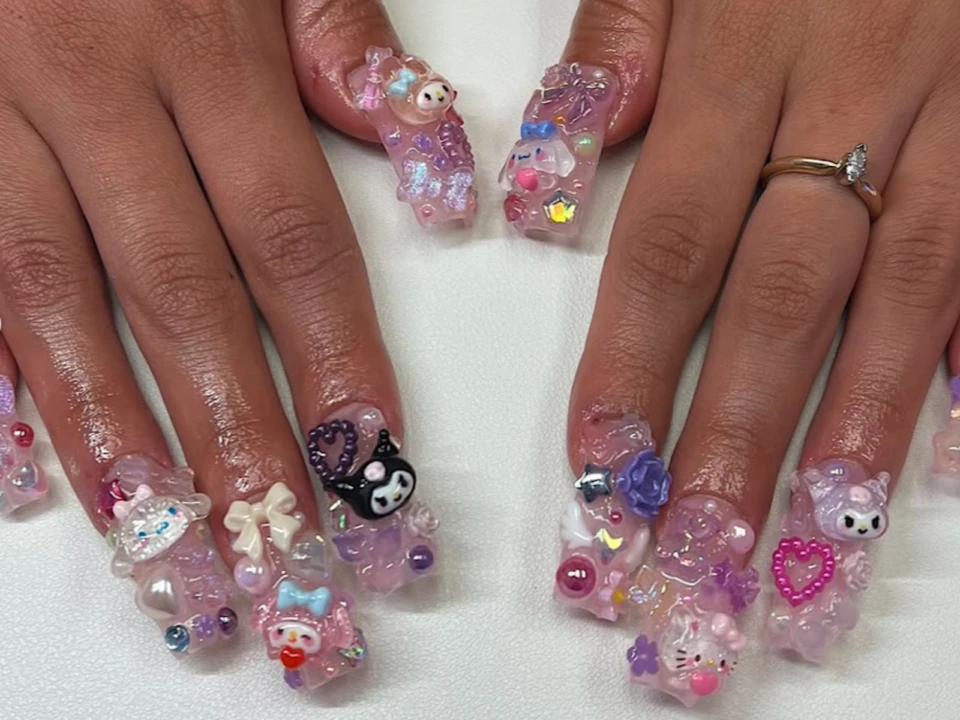 Chunky long nails bejeweled with gems and Hello Kitty charms