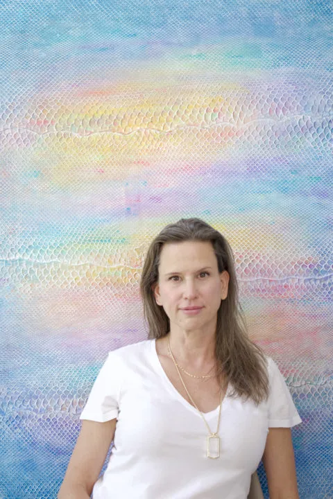 Laura Shape poses in front of her painting on python skin titled "Beautiful Stranger"