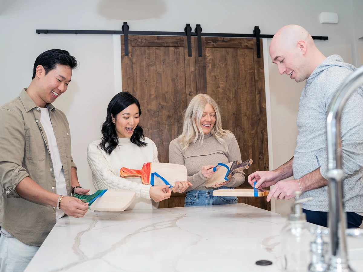 Four people with homemade charcuterie boards from Adults & Crafts