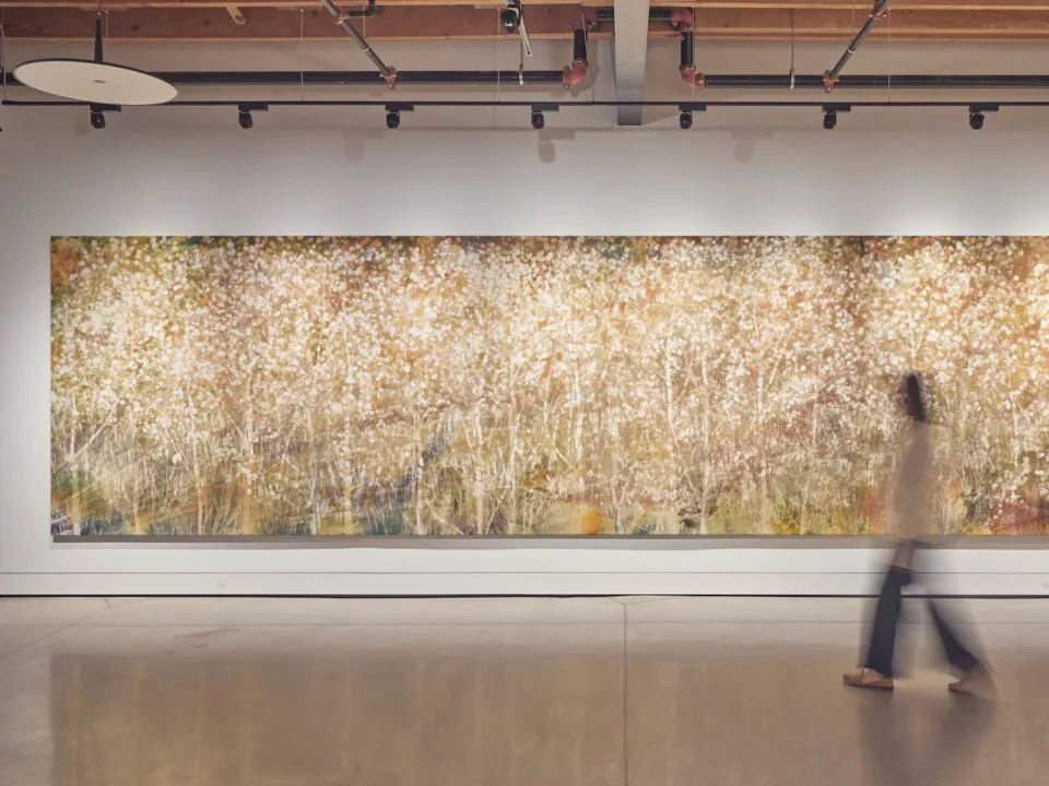 A woman walks in front of a large-scale painting