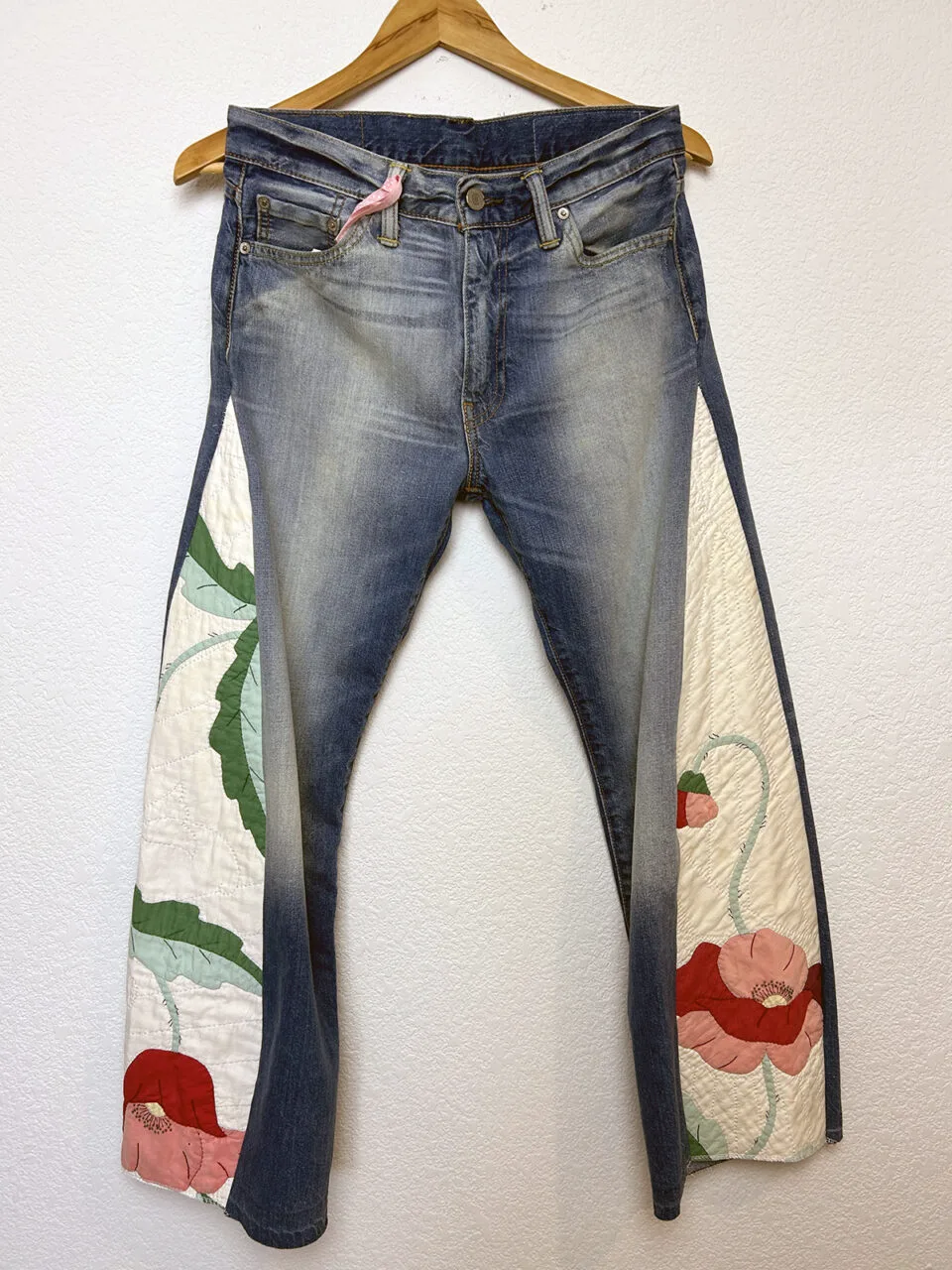 Jeans with quilted pleats on a hanger