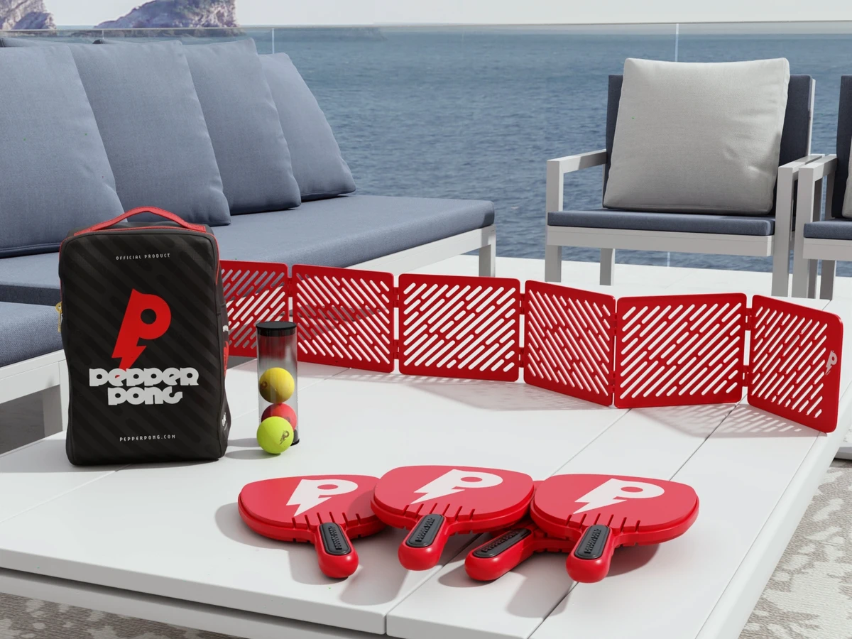 Pepper Pong equipment pieces on a white table in front of the ocean
