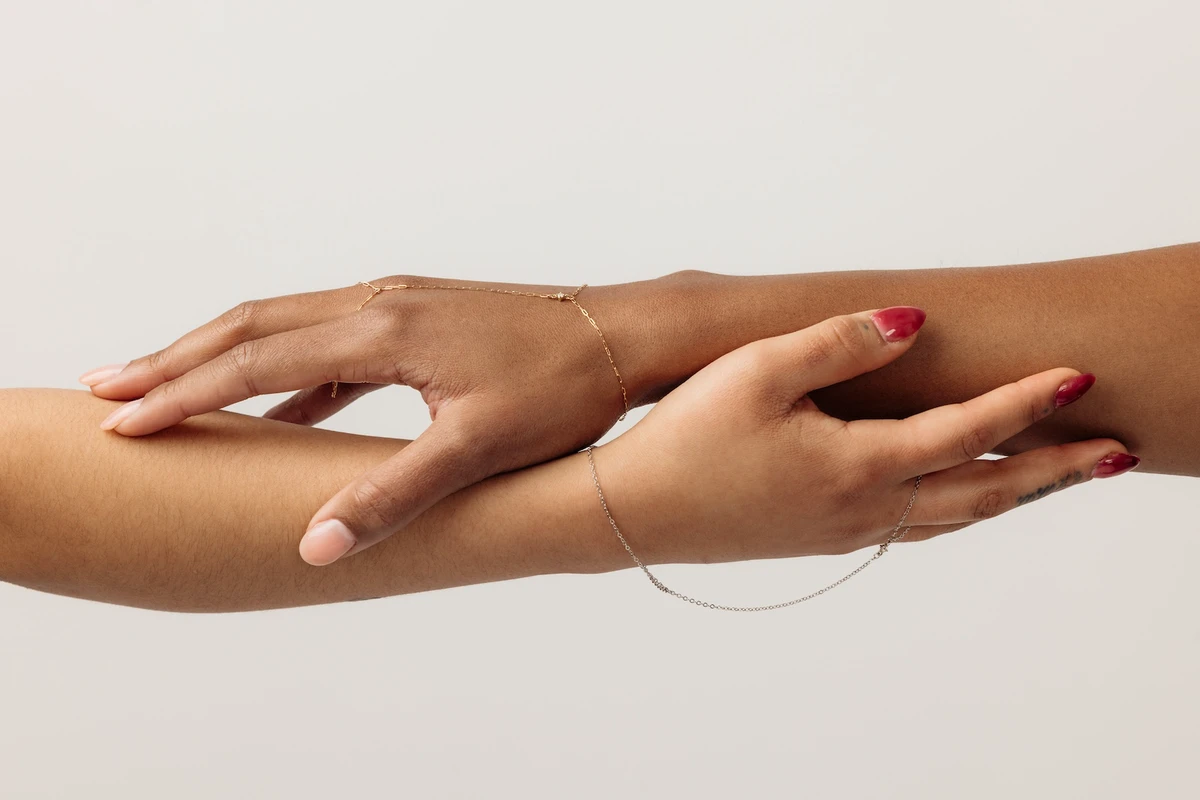 Two people's hands overlaid with a hand chains