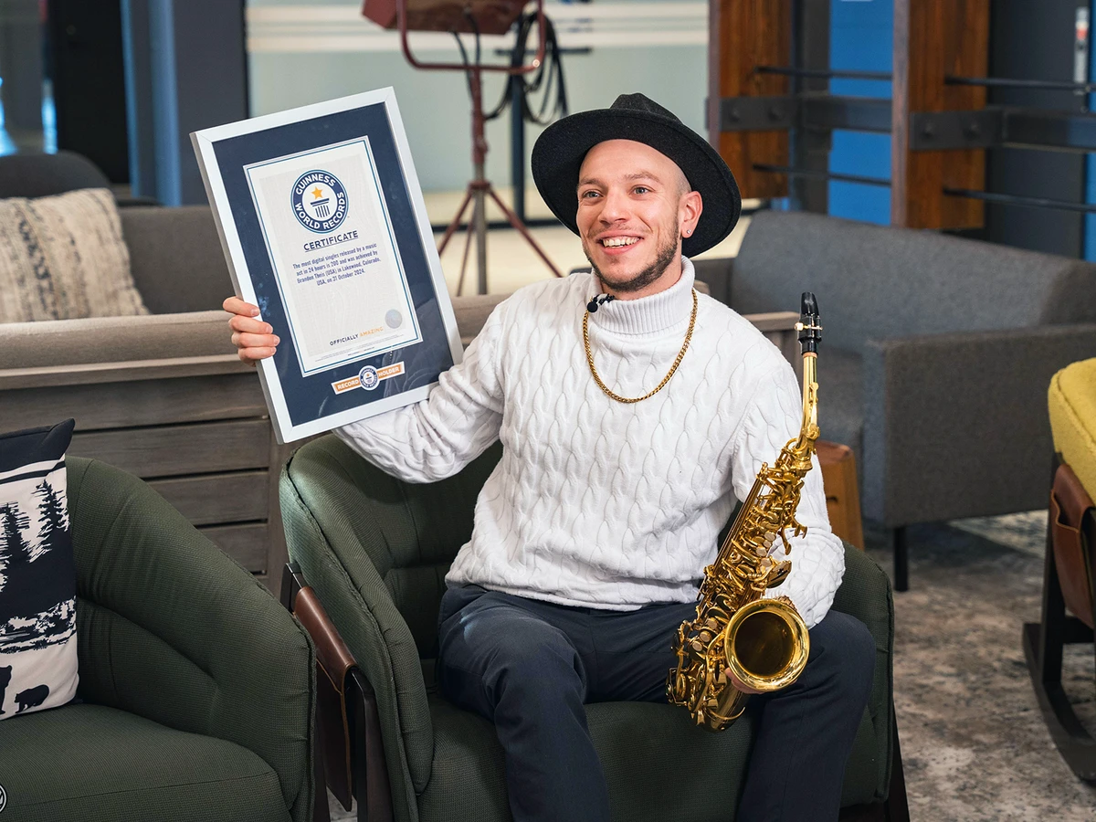 Brandon Theis, aka the Orchestrator, poses with his Guinness World Records plaque