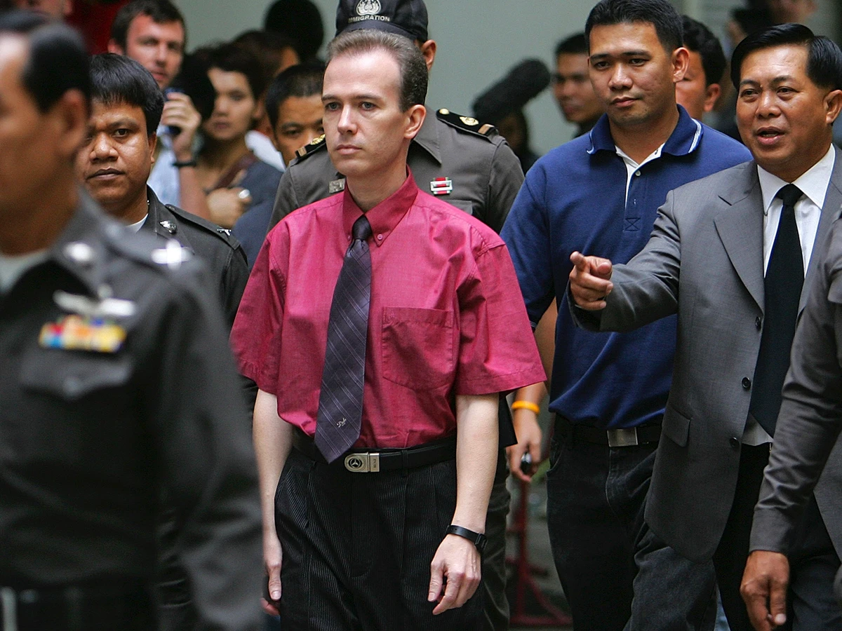 John Mark Karr surrounded by Thai officials