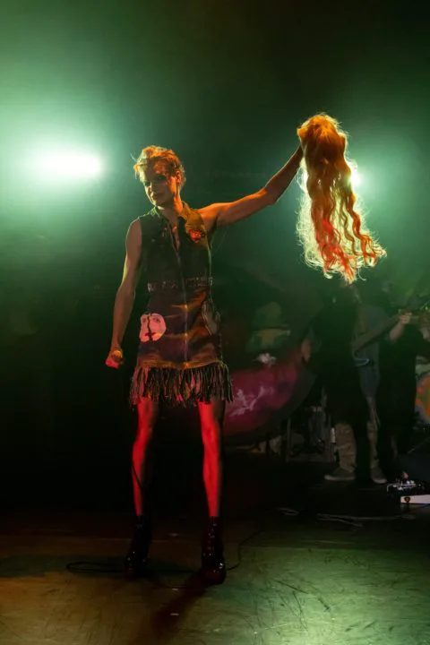 Hedwig, played by Clark Destin Jones, holds up her wig