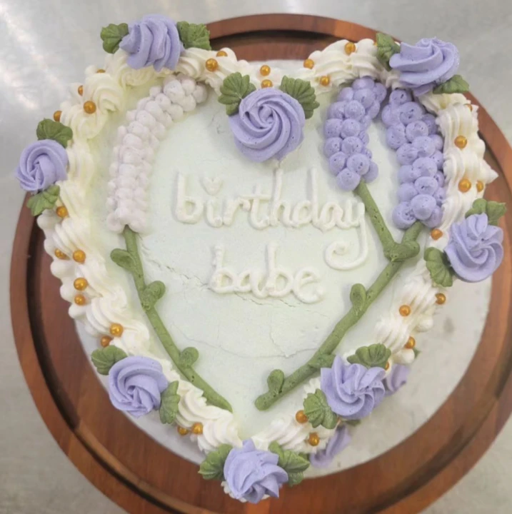 A heart shaped cake that says Birthday Babe in icing from PlayHaus Bakery