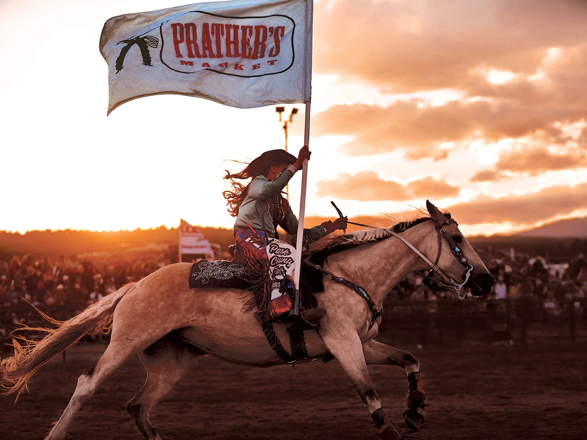 Woman on horseback with flag at Park County Fair