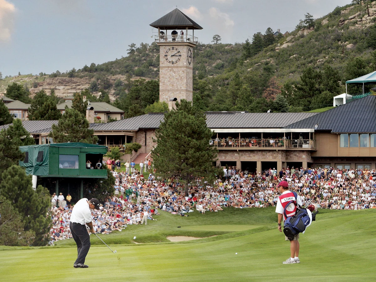 guy golfing with tower & onlookers