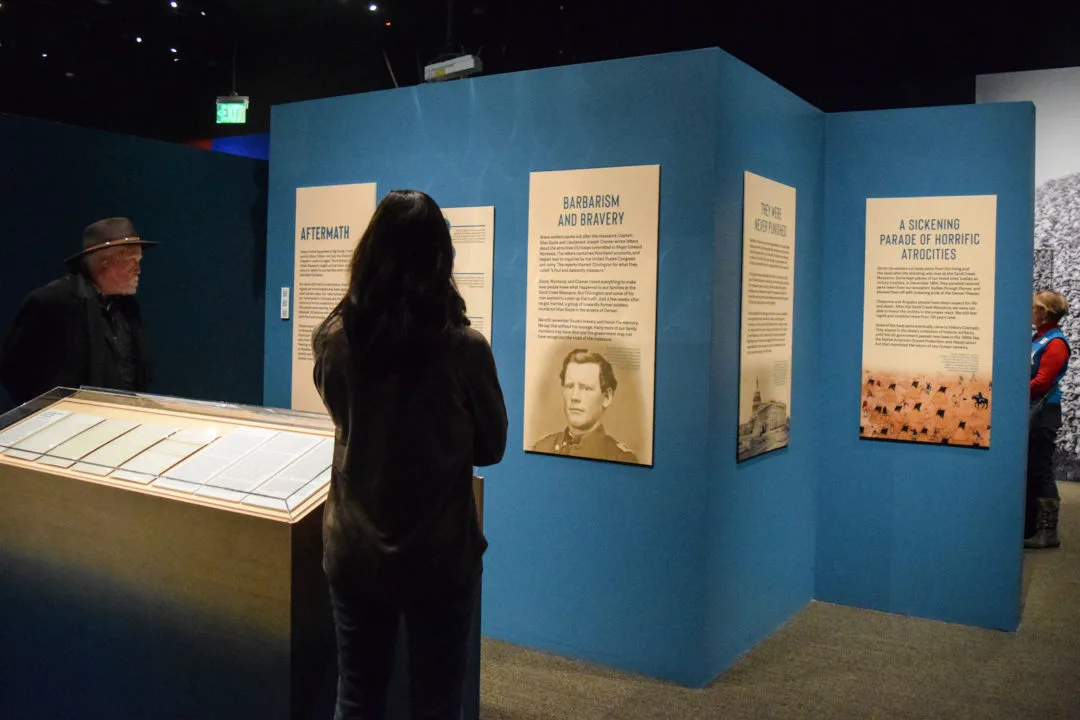 A photo of a visitor viewing the Sand Creek Massacre exhibit at History Colorado Center. Photo by Barbara Urzua